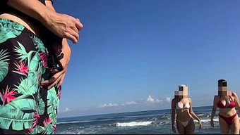 两个小妞在沙滩上和男...