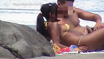 业余少女在海滩上与男...